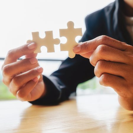 Business woman hands connecting jigsaw puzzle. Business solutions, success and strategy concept. Businessman hand connecting jigsaw puzzle.Close up photo with selective focus.