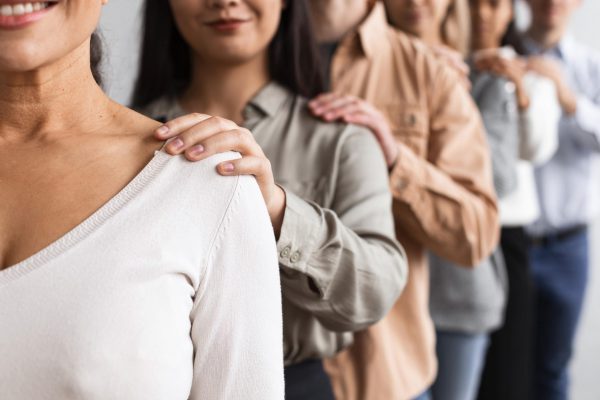 smiley-people-touching-shoulders-at-a-group-therapy-session