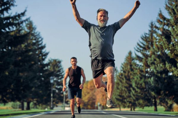 The old and young sportsmen running on the road